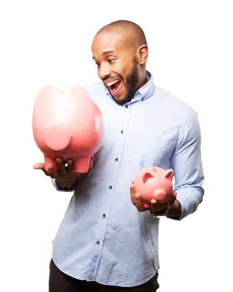 Black businessman with pink piggybanks — Stock Photo, Image