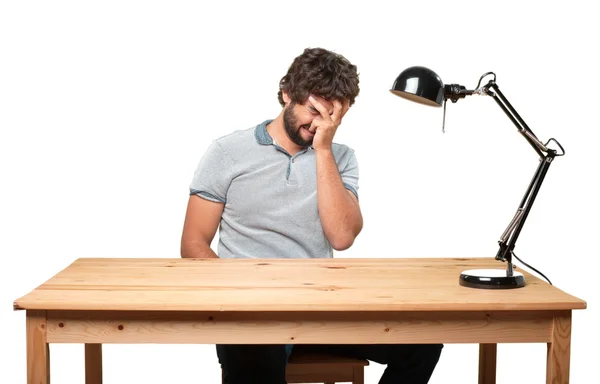 Crazy man at table with sad expression — Stock Photo, Image