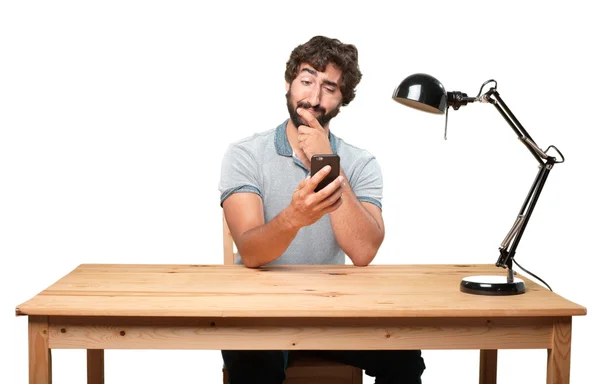 Šílený muž pomocí mobilního telefonu u stolu — Stock fotografie