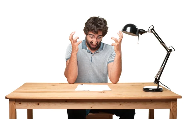 Crazy young man at table with paper — Stock Photo, Image