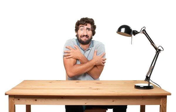 Junger Mann auf einem Tisch mit besorgtem Gesichtsausdruck — Stockfoto