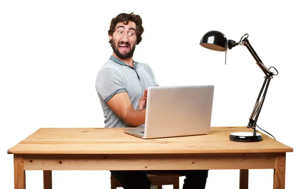 Gek jonge man aan tafel met laptop — Stockfoto