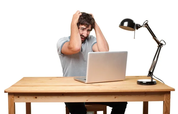 Őrült fiatal ember asztalhoz a laptop — Stock Fotó