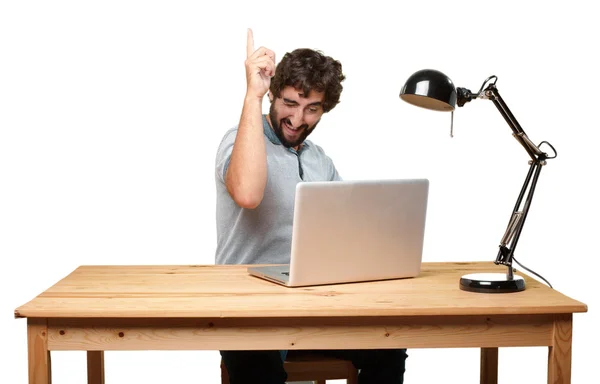 Verrückter junger Mann am Tisch mit Laptop — Stockfoto