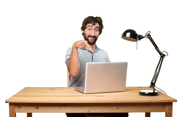 Verrückter junger Mann am Tisch mit Laptop — Stockfoto