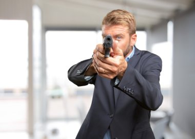 elinde tabanca ile sarışın iş adamı