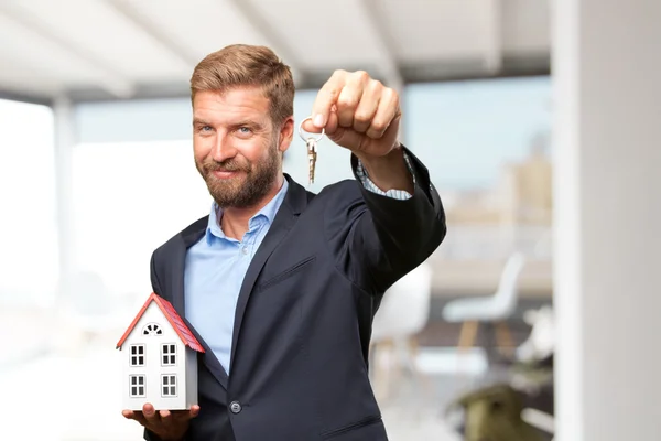 Blonder Geschäftsmann mit Spielzeughaus und Schlüssel — Stockfoto