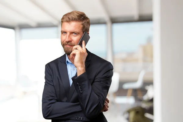 Блондин-бизнесмен разговаривает по мобильному телефону — стоковое фото