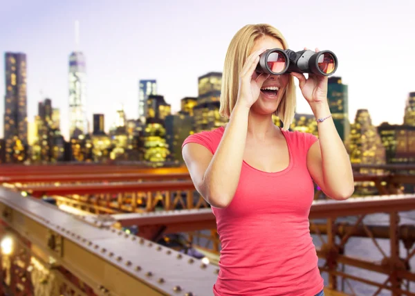 Blonde girl looking through binoculars — Stock Photo, Image