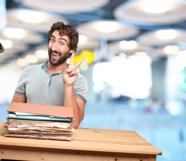 Crazy young man at table with documents — Stock Photo, Image