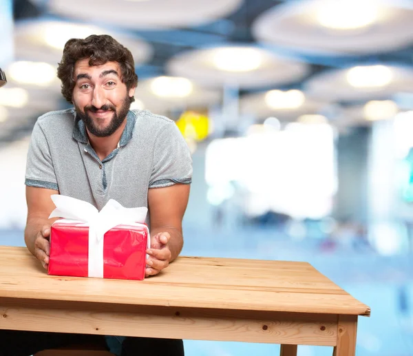 Man at table with gift box — Stock Photo, Image