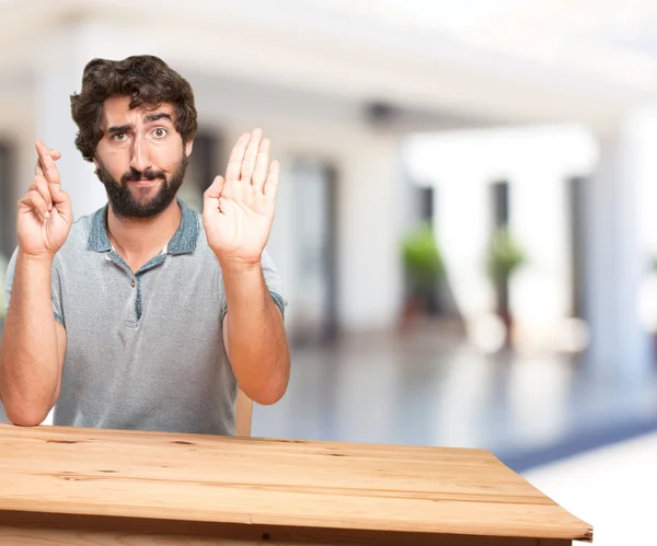 Junger Mann am Tisch mit besorgtem Gesichtsausdruck — Stockfoto