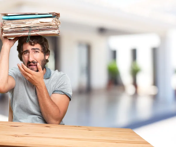 Crazy young man at table with documents — Stock Photo, Image