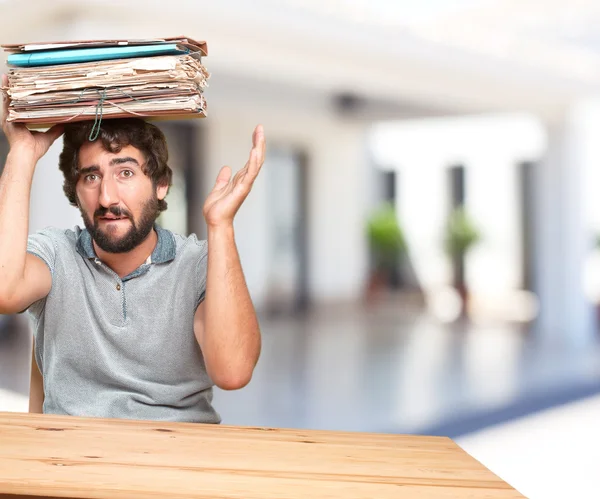 Verrückter junger Mann am Tisch mit Dokumenten — Stockfoto