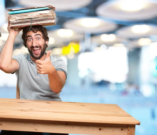Crazy young man at table with documents — Stock Photo, Image