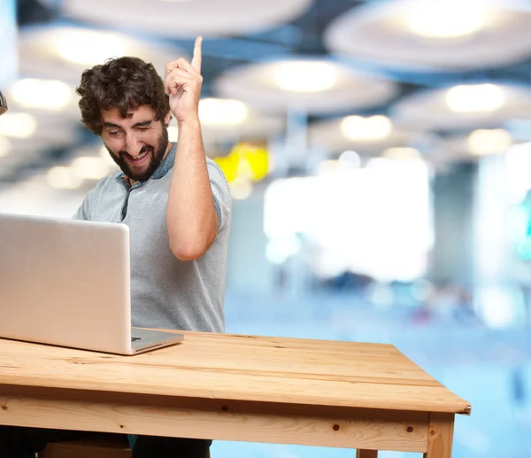 Galen unge mannen vid bordet med laptop — Stockfoto