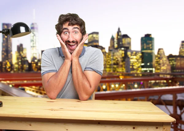 Crazy man aan tafel met verrast expressie — Stockfoto