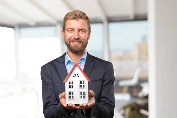 Blonder Geschäftsmann mit Spielzeughaus — Stockfoto