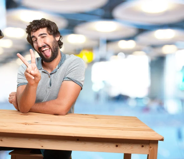 Hombre sentado en la mesa con expresión feliz — Foto de Stock