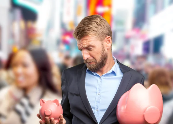 Blond businessman with pink piggybanks — Stock Photo, Image