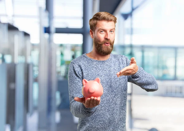 Blonder Mann mit rosa Sparschwein — Stockfoto