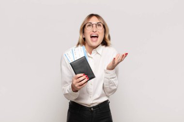 Genç sarışın kadın umutsuz ve sinirli görünüyor, stresli, mutsuz ve sinirli, bağırıyor ve çığlık atıyor.