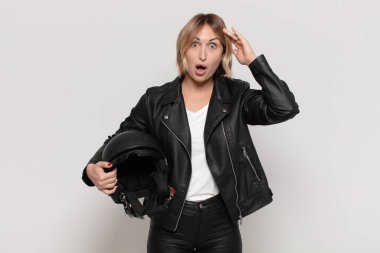 Genç sarışın kadın mutlu, şaşkın ve şaşırmış görünüyor, gülümsüyor ve inanılmaz ve inanılmaz iyi haberleri fark ediyor.