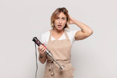 Genç sarışın kadın kendini stresli, endişeli, endişeli ya da korkmuş hissediyor. Elleri başının üstünde, hatayla panikliyor.