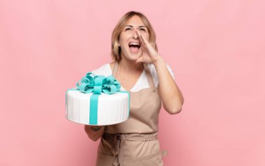 Genç sarışın kadın mutlu, heyecanlı ve pozitif hissediyor. Elleri ağızda, bağırarak bağırıyor.