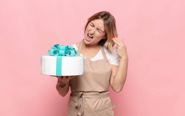 Genç sarışın kadın mutsuz ve stresli görünüyor, intihar jesti silahla işaret ediyor, kafasını işaret ediyor.