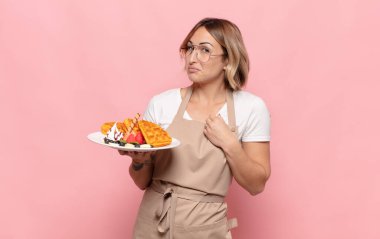 Genç sarışın kadın kibirli, başarılı, pozitif ve gururlu görünüyor.