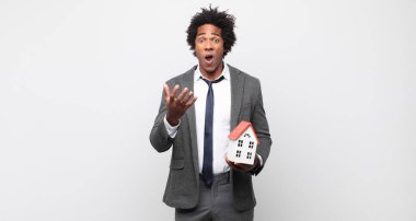 Genç siyah afro adam umutsuz görünüyor ve hayal kırıklığına uğramış, stresli, mutsuz ve sinirli, bağırıyor ve çığlık atıyor.