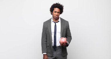 Genç siyah afro adam üzgün ve mızmız, mutsuz bir bakışla ağlıyor, olumsuz ve hayal kırıklığına uğramış bir tavırla.