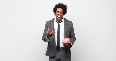 Genç siyahi afro adam sinirli, sinirli ve sinirli görünüyor. Senin neyin var? 