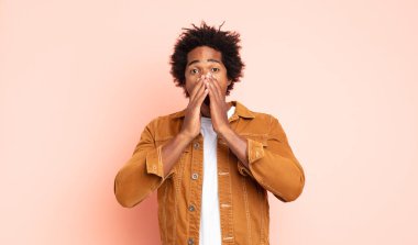 Genç siyah afro adam mutlu, heyecanlı ve pozitif hissediyor, elleri ağızlarının yanında bağırıyor, bağırıyor