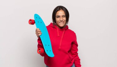 Genç İspanyol kadın şaşkın ve şaşkın görünüyor. Sinirli bir hareketle dudağını ısırıyor. Sorunun cevabını bilmiyor.