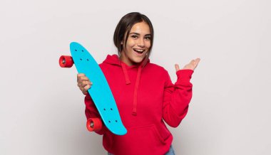 Genç İspanyol kadın mutlu, şaşırmış ve neşeli hissediyor, olumlu bir tavırla gülümsüyor, bir çözüm ya da fikri fark ediyor.