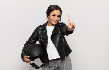 Genç İspanyol kadın gülümsüyor ve arkadaş canlısı görünüyor, bir numara veya ilk eli önde, geriye doğru sayıyor.