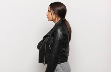 Profil görünümlü genç İspanyol kadın uzayı kopyalamaya çalışıyor, düşünüyor, hayal ediyor ya da hayal kuruyor.