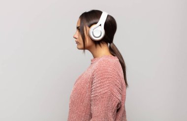 Profil görünümlü genç İspanyol kadın uzayı kopyalamaya çalışıyor, düşünüyor, hayal ediyor ya da hayal kuruyor.