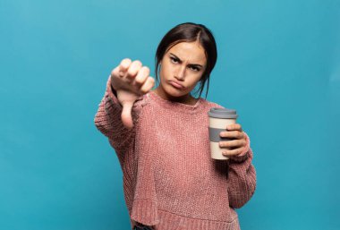 Genç İspanyol kadın kızgın, sinirli, hayal kırıklığına uğramış ya da canı sıkkın, ciddi bir bakışla başparmağını kaldırıyor.