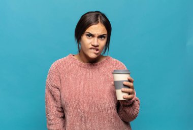 Genç İspanyol kadın şaşkın ve şaşkın görünüyor. Sinirli bir hareketle dudağını ısırıyor. Sorunun cevabını bilmiyor.