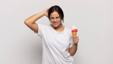 Genç İspanyol kadın kendini stresli, endişeli, endişeli ya da korkmuş hissediyor. Elleri başının üstünde, hatayla panikliyor.