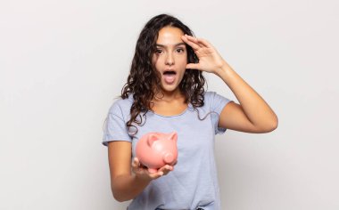 Genç İspanyol kadın mutlu, şaşkın ve şaşırmış görünüyor, gülümsüyor ve inanılmaz ve inanılmaz iyi haberleri fark ediyor.