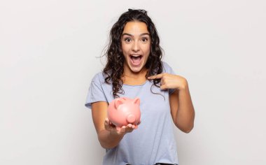 Genç İspanyol kadın mutlu, şaşkın ve gururlu hissediyor. Heyecanlı ve şaşkın bir bakışla kendini işaret ediyor.