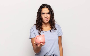 Genç İspanyol kadın şaşkın ve şaşkın görünüyor. Sinirli bir hareketle dudağını ısırıyor. Sorunun cevabını bilmiyor.