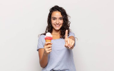 Genç İspanyol kadın gülümsüyor ve arkadaş canlısı görünüyor, bir numara veya ilk eli önde, geriye doğru sayıyor.