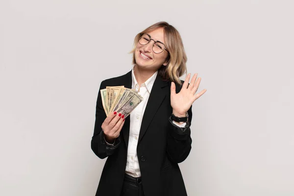 Young Blonde Woman Smiling Happily Cheerfully Waving Hand Welcoming Greeting — Stock Photo, Image