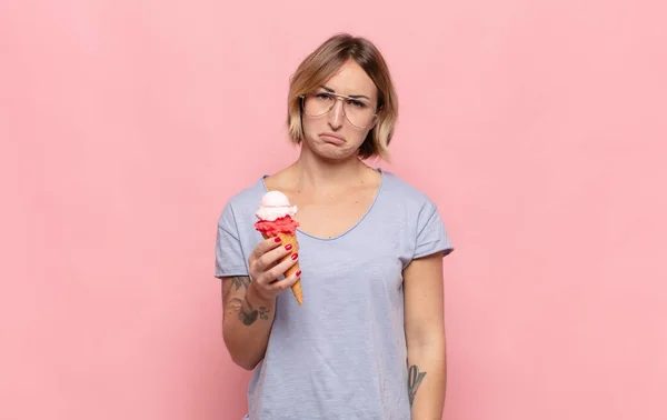 young blonde woman feeling sad and whiney with an unhappy look, crying with a negative and frustrated attitude