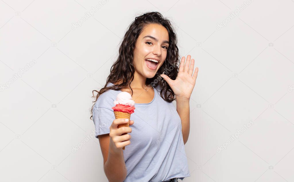 young hispanic woman smiling happily and cheerfully, waving hand, welcoming and greeting you, or saying goodbye